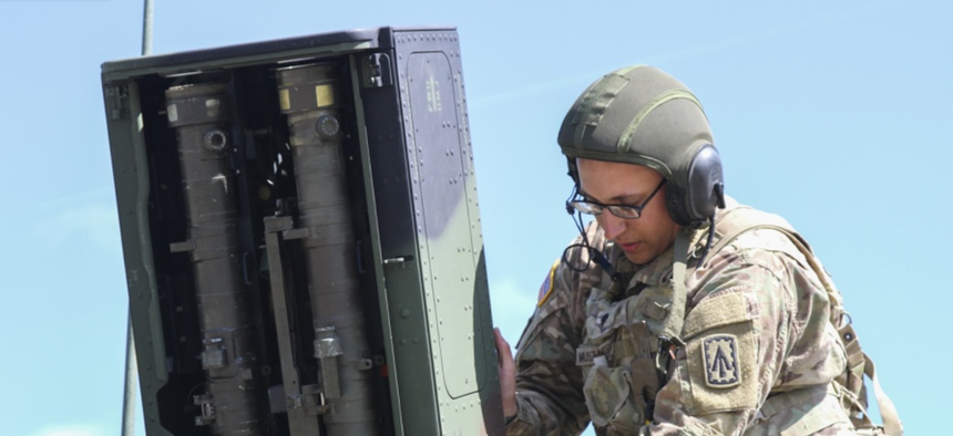 Spc. Bradley Muszalski, an air and missile defense crewmember with the 101st Airborne Division closes the door to an Avenger anti-aircraft missile launcher pod.