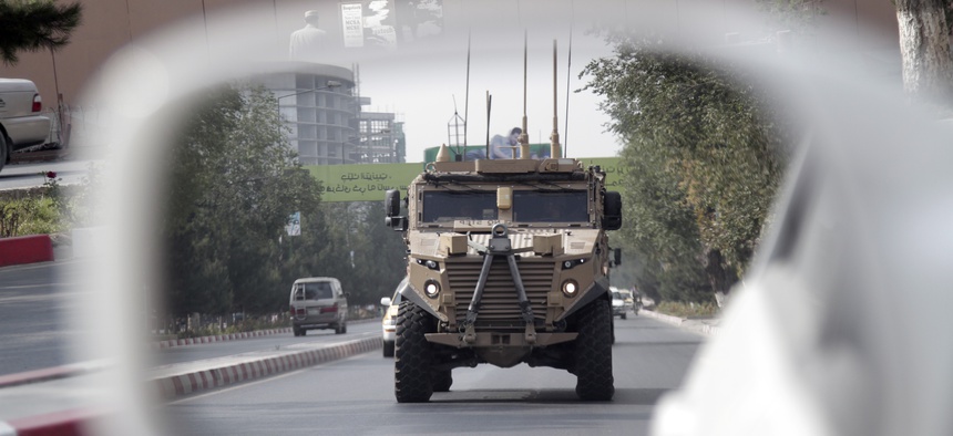 A patrolling U.S. armored vehicle is reflected in the mirror of a car in Kabul, Afghanistan, Wednesday, Aug. 23, 2017.