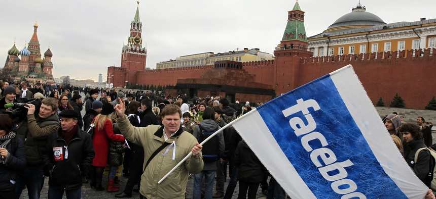 Opposition supporter waves a Facebook flag during a protest at the Red Square in Moscow, Sunday, April 8, 2012. Opposition activists called for supporters to walk around Red Square on Sunday wearing the white ribbons that have become a protest symbol.
