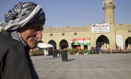 Saber Salim sits outside Irbil's Citadel near a campaign poster urging people to vote 'yes' in September's schedule referendum on independence from Iraq, Aug. 24, 2017. Saber Salim sits outside Irbil's Citadel near a campaign poster urging people to vote 'yes' in September's schedule referendum on independence from Iraq, Aug. 24, 2017.