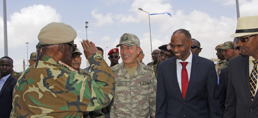 Turkish Chief of Staff General Hulusi Akar, second left, and Somali Prime Minister Hassan Ali Khayre, second right, receive a salute from a Somali soldier at combined Turkey-Somali training center during his visit to Mogadishu, Somalia, Sept. 30, 2017.