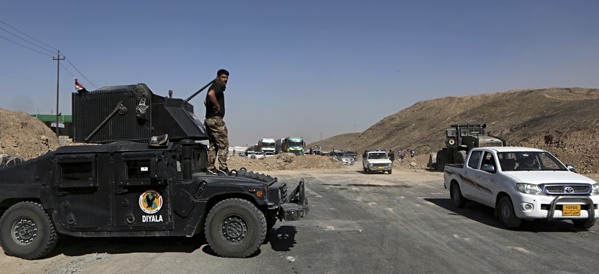 Federal security forces and local police stand guard in the northern entrance of Kirkuk while people return back to Kirkuk, 290 kilometers (180 miles) north of Baghdad, Iraq, Tuesday, Oct. 17, 2017.