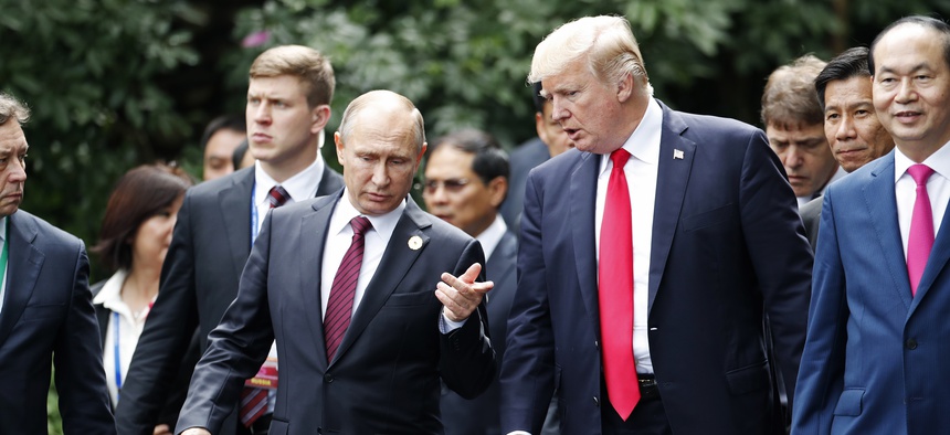 U.S. President Donald Trump, center right, and Russia's President Vladimir Putin, center left, talk during the family photo session at the APEC Summit in Danang, Saturday, Nov. 11, 2017.