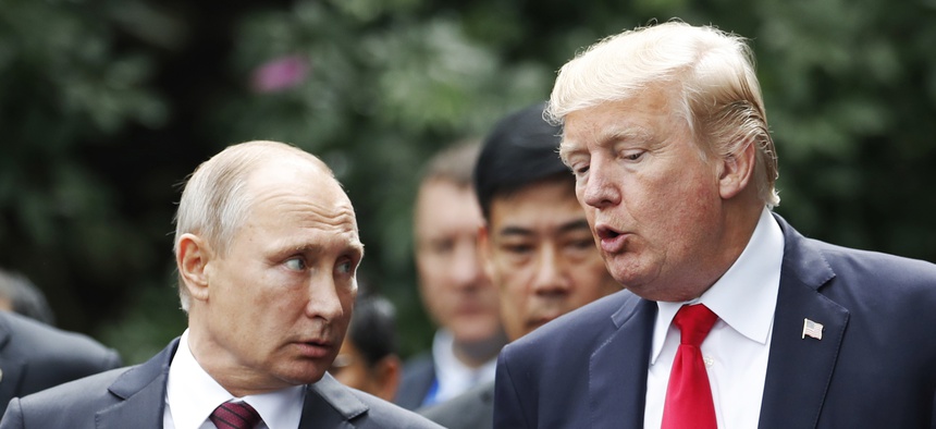 U.S. President Donald Trump and Russia's President Vladimir Putin talk during the family photo session at the APEC Summit in Danang, Vietnam, Saturday, Nov. 11, 2017.