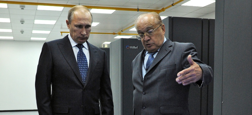Russian President Vladimir Putin listens to an explanation of the head of Moscow's State University Viktor Sadovnichy, right, during a visit to laboratory, where super computer Lomonosov is placed, at the university on Thursday, Oct. 30, 2014