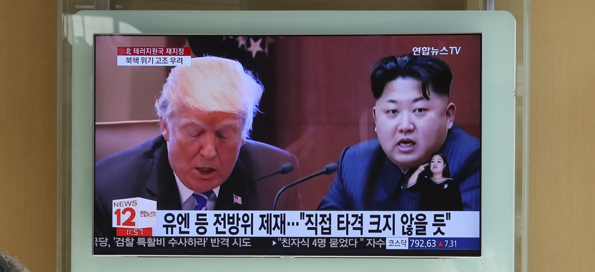People watch a TV screen showing images of U.S. President Donald Trump, left, and North Korean leader Kim Jong Un at Seoul Railway Station in Seoul, South Korea, Nov. 21, 2017.