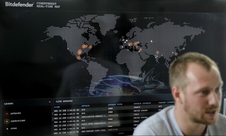 Bogdan Botezatu, a cyberthreats specialist with Bitdefender speaks during an interview with the Associated Press, backdropped by a real time cyber-attacks world map, at the headquarters of Bitdefender in Bucharest, Romania, Wednesday, June 28, 2017. Bogdan Botezatu, a cyberthreats specialist with Bitdefender speaks during an interview with the Associated Press, backdropped by a real time cyber-attacks world map, at the headquarters of Bitdefender in Bucharest, Romania, Wednesday, June 28, 2017.