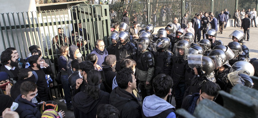 In this photo taken by an individual not employed by the Associated Press and obtained by the AP outside Iran, anti-riot Iranian police prevent university students to join other protesters over Iran weak economy, in Tehran, Iran, Saturday, Dec. 30, 2017.