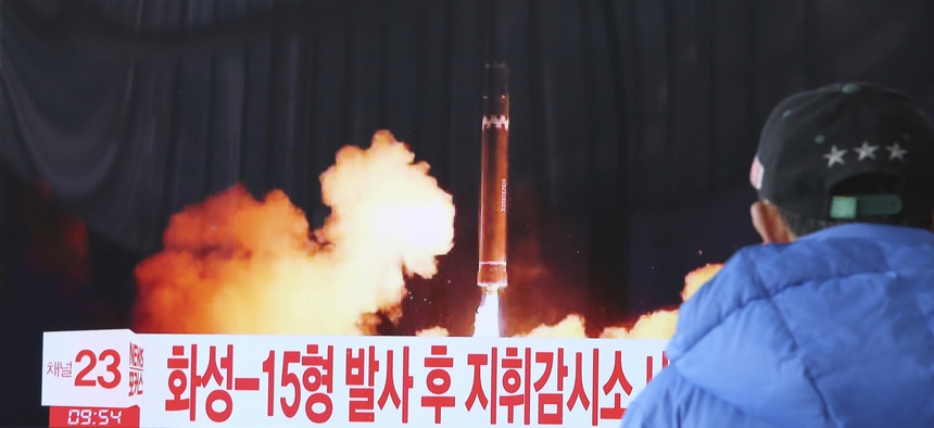 A man watches a TV screen showing what the North Korean government calls the Hwasong-15 intercontinental ballistic missile.