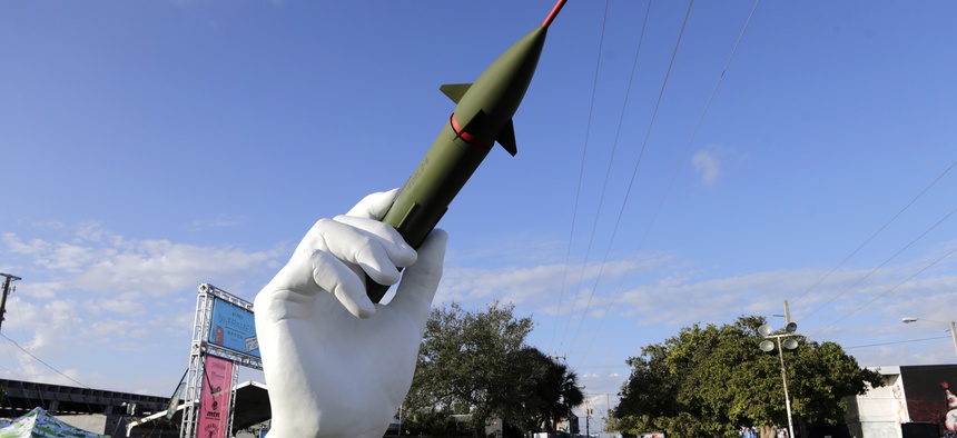 A sculpture titled "Dangerous Game" by Italian artist Lorenzo Quinn, right, is displayed in the Wynwood neighborhood of Miami, Friday, Dec. 8, 2017.