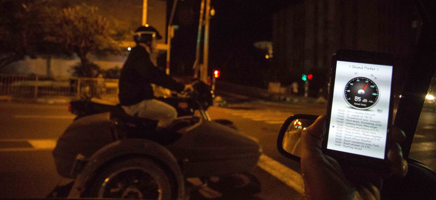 In this Nov. 20, 2016 photo, a sound meter on a mobile phone shows 89 decibels as a motorcycle with a side car drones by on 23rd street in Havana, Cuba.