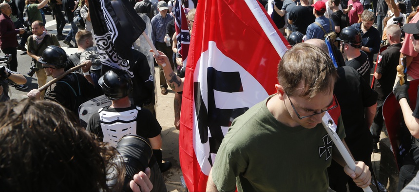 An Aug. 12, 2017, image shows a white supremacist carrying a NAZI flag into the entrance to Emancipation Park in Charlottesville, Va.