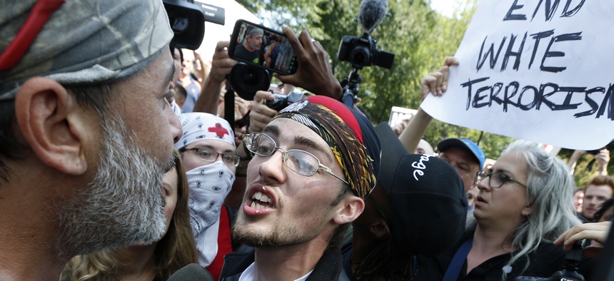 In this Aug. 19, 2017 file photo, a supporter of President Donald Trump, center, argues with a counterprotester, left, at a "Free Speech" rally by conservative activists on Boston Common in Boston.
