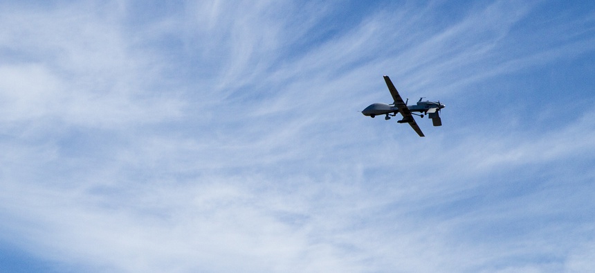 An MQ-1C Gray Eagle unmanned aerial system flies over Division Artillery as they fire during the Mass Fire Mission on Fort Stewart March 1, 2016.