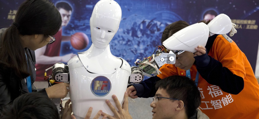 , Chinese students work on the Ares, a humanoid bipedal robot designed by them with fundings from a Shanghai investment company, displayed during the World Robot Conference in Beijing. Photo taken October 21, 2016