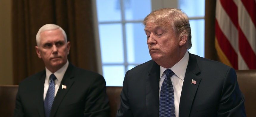 President Donald Trump, right, sitting next to Vice President Mike Pence, left, speaks in the Cabinet Room of the White House in Washington, April 9, 2018, at the start of a meeting with military leaders.