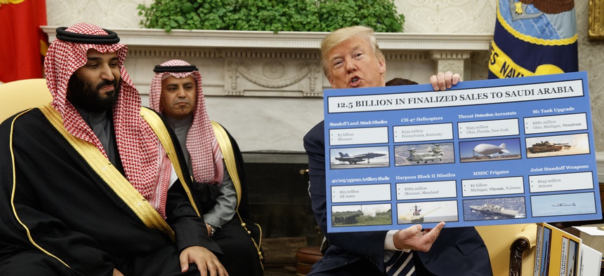 President Donald Trump shows a chart highlighting arms sales to Saudi Arabia during a meeting with Saudi Crown Prince Mohammed bin Salman in the Oval Office of the White House, Tuesday, March 20, 2018, in Washington.