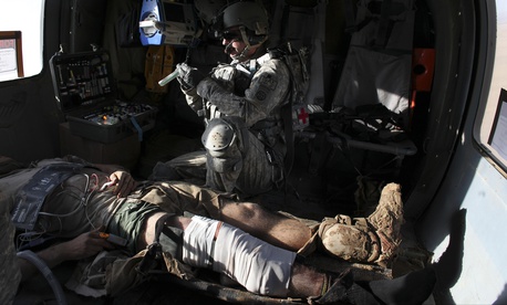 Airborne in a Black Hawk helicopter, U.S. Army flight medic Staff Sgt. Robert B. Cowdrey, of La Junta, Colo., with Charlie Company, All American Dustoff, attends to a U.S. Marine wounded in a rocket-propelled grenade attack, over Marjah, Helmand province, Airborne in a Black Hawk helicopter, U.S. Army flight medic Staff Sgt. Robert B. Cowdrey, of La Junta, Colo., with Charlie Company, All American Dustoff, attends to a U.S. Marine wounded in a rocket-propelled grenade attack, over Marjah, Helmand province,