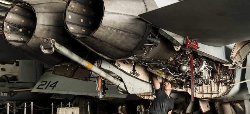 U.S. Navy Aviation Machinist's Mate 2nd Class Alexandra Mimbela performs maintenance on an F/A-18F Super Hornet aircraft assigned to Strike Fighter Squadron (VFA) 213 aboard the aircraft carrier USS George H.W. Bush (CVN 77) Aug. 21, 2014.