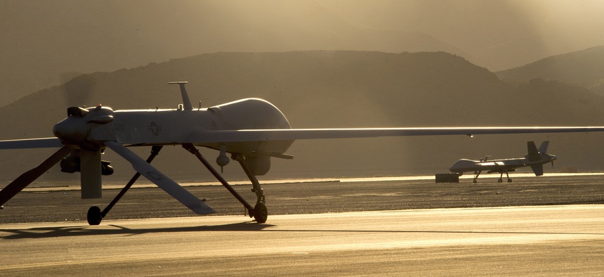 An MQ-1B Predator, left, and an MQ-9 Reaper taxi to the runway in preparation for takeoff June 13, 2014, at Creech Air Force Base, Nev.