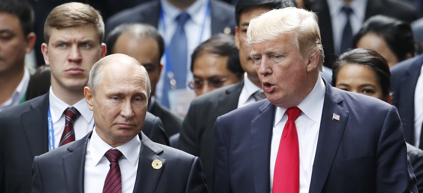 U.S. President Donald Trump and Russia's President Vladimir Putin talk during the family photo session at the APEC Summit in Danang, Saturday, Nov. 11, 2017.