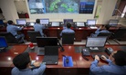 Workers sit at computer terminals as they monitor a large display screen in the command center at the Sinopec Yanshan Petrochemical Company on the outskirts of Beijing, Friday, May 25, 2018.