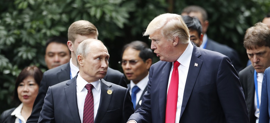 U.S. President Donald Trump, center right, and Russia's President Vladimir Putin, center left, talk during the family photo session at the APEC Summit in Danang, Saturday, Nov. 11, 2017.