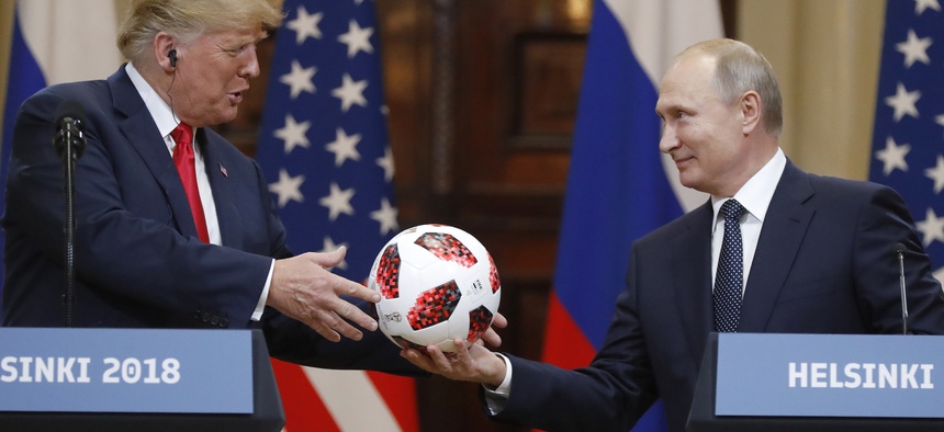 Russian President Vladimir Putin gives a soccer ball to U.S. President Donald Trump, left, during a press conference after their meeting at the Presidential Palace in Helsinki, Finland, Monday, July 16, 2018.