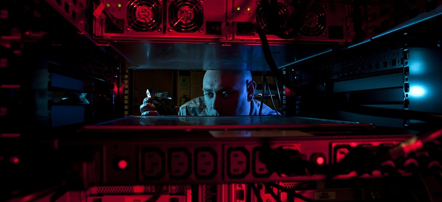 U.S. Air Force Staff Sgt. Jerome Duhan, a network administrator with the 97th Communications Squadron, inserts a hard drive into the network control center retina server at Altus Air Force Base.