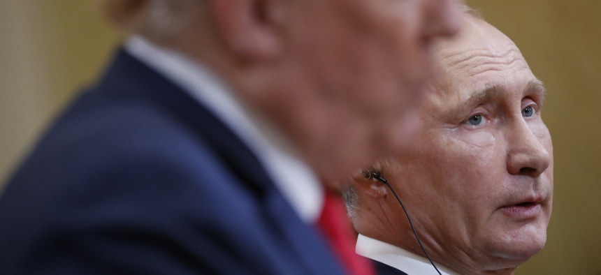 Russian President Vladimir Putin, right, listens to U.S. President Donald Trump, right, speak during their joint news conference at the Presidential Palace in Helsinki, Finland, Monday, July 16, 2018.
