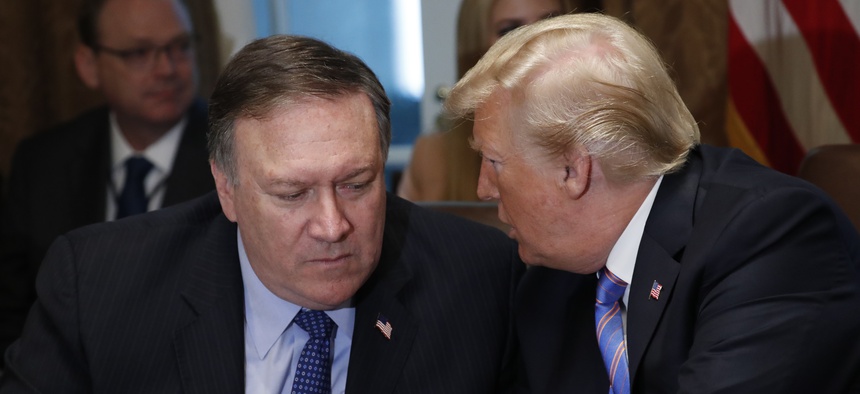 President Donald Trump speaks with Secretary of State Mike Pompeo during his meeting with members of his cabinet in Cabinet Room of the White House in Washington, Wednesday, July 18, 2018.