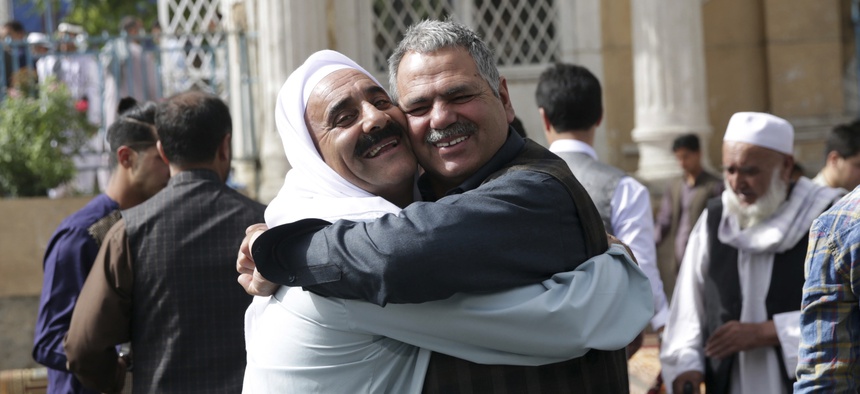Men hug each other after Eid al-Fitr prayers outside of Shah-e-Dushamshera mosque in Kabul, Afghanistan, Friday, June 15, 2018. Taliban, an insurgent group, announced that they will start a 3-day ceasefire, starting in the first day of Eid al-Fitr.