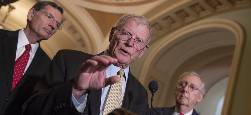 Sen. James Inhofe, R-Okla., a member of the Senate Armed Services Committee, center, joined by Sen. John Barrasso, R-Wyo., left, and Senate Majority Leader Mitch McConnell, R-Ky., talks about defense funding on Capitol Hill in Washington, June 12, 2018.