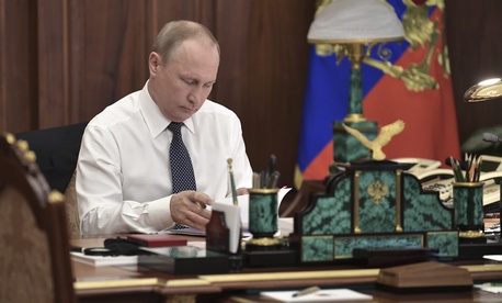 Vladimir Putin sits in his Kremlin cabinet prior his inauguration ceremony as new Russia's president in Moscow, Russia, Monday, May 7, 2018. Putin won the six-year term in March elections where he tallied 77 percent of the vote.
