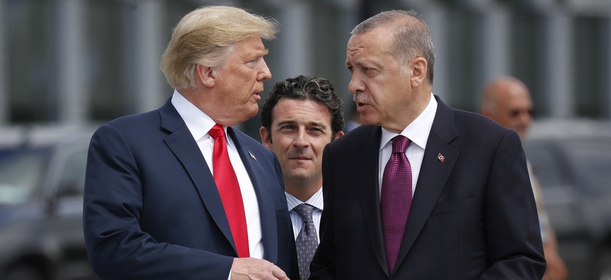 President Donald Trump, left, talks with Turkey's President Recep Tayyip Erdogan, right, as they arrive together for a family photo at a summit of heads of state and government at NATO headquarters in Brussels on Wednesday, July 11, 2018.