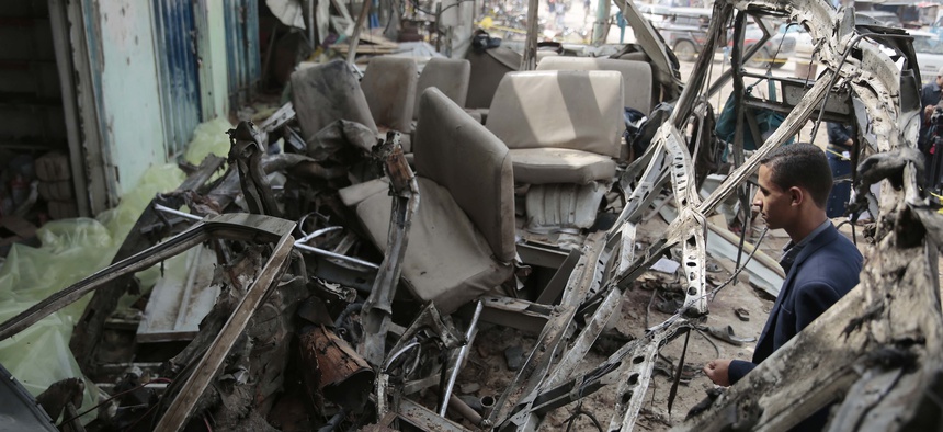 A man inspects the wreckage of a bus at the site of a deadly Saudi-led coalition airstrike on Thursday, in Saada, Yemen, Sunday, Aug. 12, 2018.