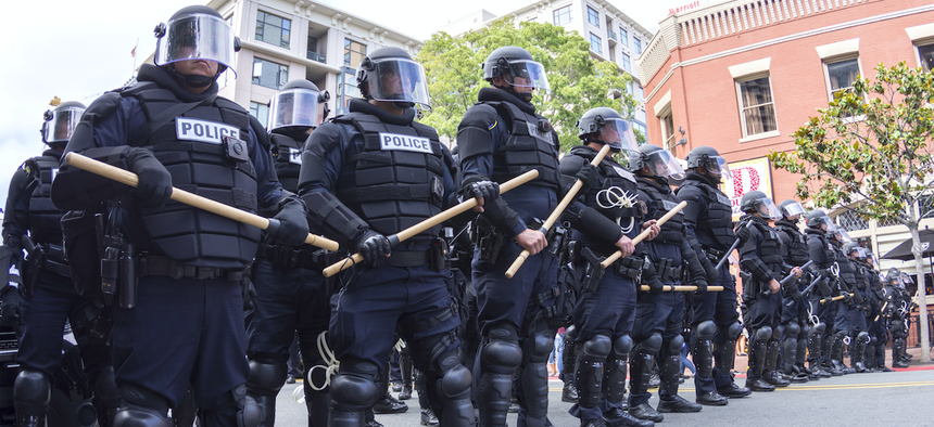Riot police in full tactical gear stand ready to confront protesters at a Trump rally at the San Diego Convention Center on May 27, 2016.