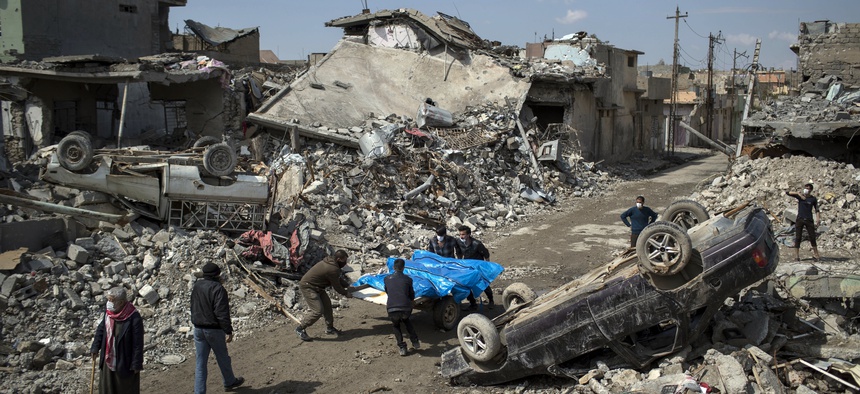 In this March 24, 2017, file photo, residents carry the body of several people killed during fights between Iraq security forces and Islamic State on the western side of Mosul, Iraq.