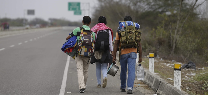 Venezuelan Omar Mujica, right, walks to Lima along the shoulder of the Pan-American Highway with other Venezuelan migrants after crossing the border from Ecuador into Peru, near Tumbes, Peru, Sunday, Aug. 26, 2018.