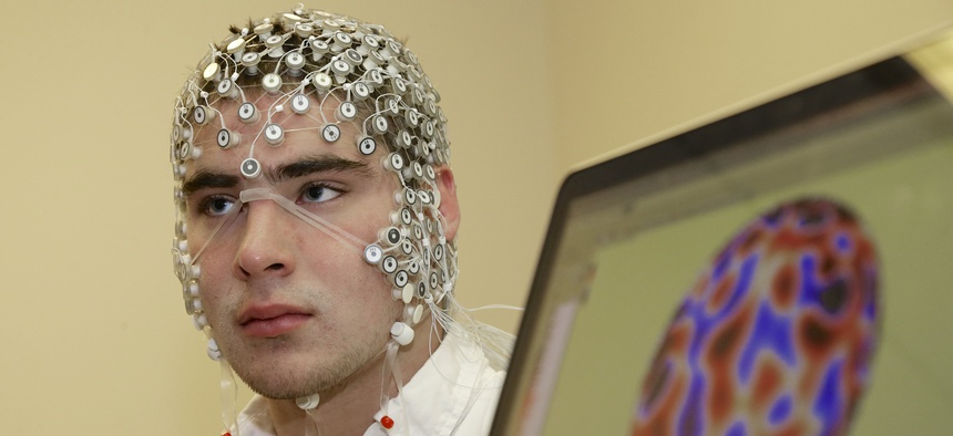 In this May 31, 2013, photo, research assistant Kevin Real wears an EEG net for detecting brain activity which is hooked up to a monitor, at the University of Nebraska's Center for Brain, Biology and Behavior in Lincoln, Neb.
