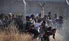In this June 14, 2015 photo taken from the Turkish side of the border between Turkey and Syria, in southeastern Turkey, Syrian refugees burst into Turkey after breaking the border fence and crossing from Syria. In this June 14, 2015 photo taken from the Turkish side of the border between Turkey and Syria, in southeastern Turkey, Syrian refugees burst into Turkey after breaking the border fence and crossing from Syria.