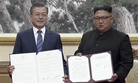 In this image made from video, South Korean President Moon Jae-in, left, and North Korean leader Kim Jong Un pose after signing documents in Pyongyang, North Korea Wednesday, Sept. 19, 2018.