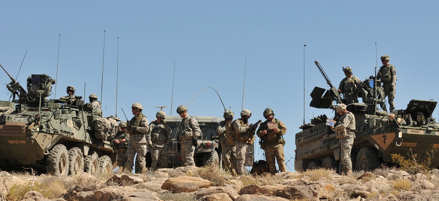 Soldiers from 4th Stryker Brigade Combat Team, 2nd Infantry Division and airmen from 5th Air Support Operations Squadron, along with observer-controllers, prepare for a Joint Air Attack Team exercise.
