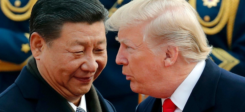 In this Nov. 9, 2017, file photo, U.S. President Donald Trump, right, chats with Chinese President Xi Jinping during a welcome ceremony at the Great Hall of the People in Beijing.