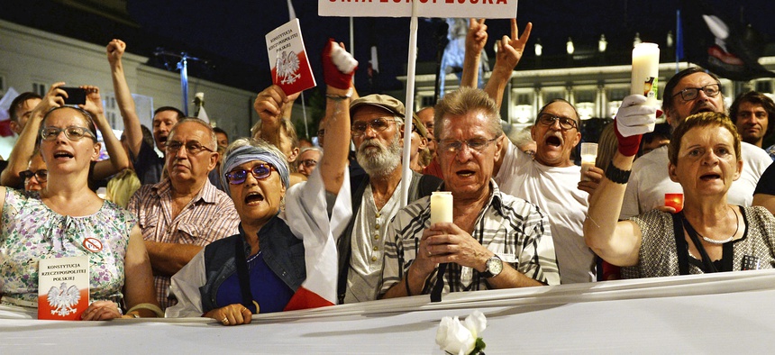 Protesters shout slogans as they gather in front of the Presidential Palace to show President Andrzej Duda their disapproval after he signed the latest legislation on the Supreme Court into law, in Warsaw, Poland, July 26, 2018.