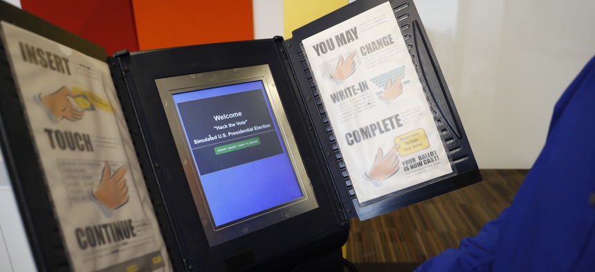 In this Wednesday, Sept. 28, 2016 photo, Brian Varner, a principal researcher at Symantec, inserts an identifying chip card into an electronic voting machine as he demonstrates how to hack an electronic voting machine at a Symantec office in New York.
