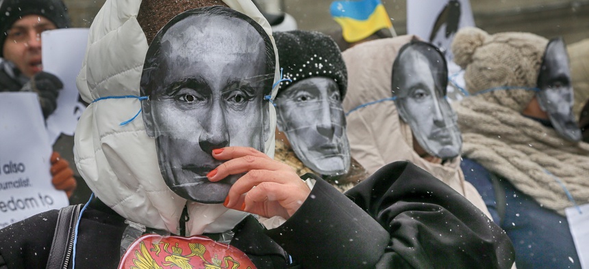 Colleagues of jailed journalist Roman Sushchenko wear masks depicting Russian President Vladimir Putin during a protest in front of the Russian Embassy demanding his release in Kiev, Ukraine, Wednesday, Nov. 2, 2016.