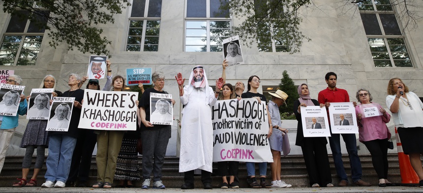 People hold signs at the Embassy of Saudi Arabia during protest about the disappearance of Saudi journalist Jamal Khashoggi, Wednesday, Oct. 10, 2018, in Washington.