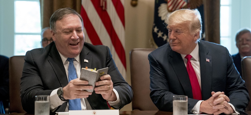 Secretary of State Mike Pompeo, left, accompanied by President Donald Trump, speaks before reading a prayer at the beginning of a cabinet meeting in the Cabinet Room of the White House, Thursday, Aug. 16, 2018, in Washington.