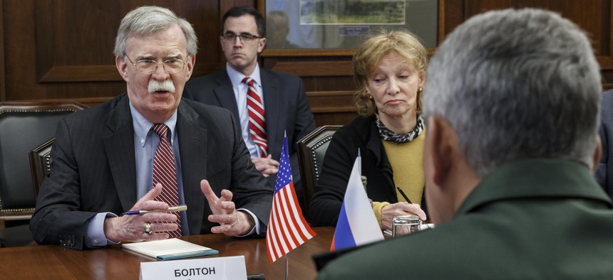 U.S. National Security Adviser John Bolton, left, gestures while speaking to Russian Defense Minister Sergei Shoigu, back to a camera, during their meeting in Moscow, Russia, Tuesday, Oct. 23, 2018.